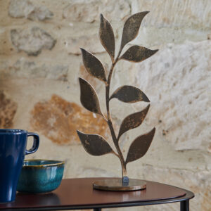 Totem Zéphyr en acier, design élégant et moderne, posé sur une table avec des tasses dans un intérieur contemporain.