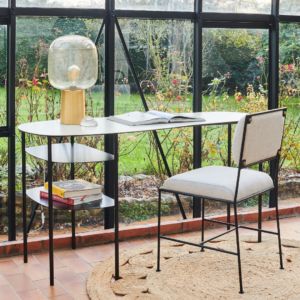 Bureau élégant en acier avec rangement intégrée, accompagné d'une chaise moderne, dans un cadre lumineux et verdoyant.