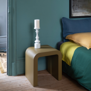 Chevet en acier Gaïa, finition contemporaine, avec une bougie blanche sur un fond de lit coloré.