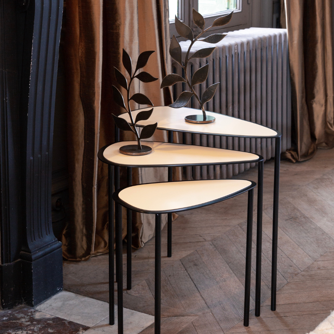 Table gigogne Héra crème, design épuré en acier, mise en scène élégante dans un intérieur moderne.