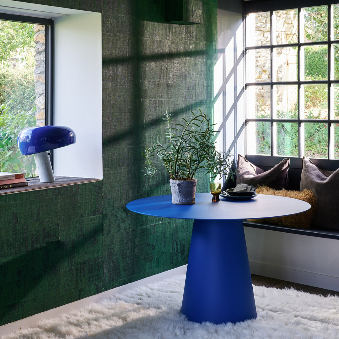 Table de salle à manger Lombok extérieure, design épuré en acier, mise en scène moderne avec plantes et luminaires.