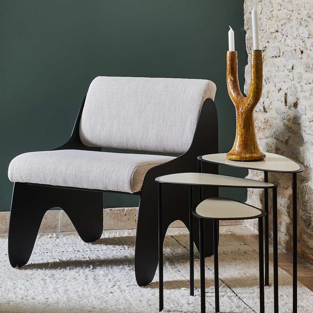 Chaise gigogne Héra crème, design contemporain, avec table d'appoint stylée et décor moderne sur fond de mur vert.