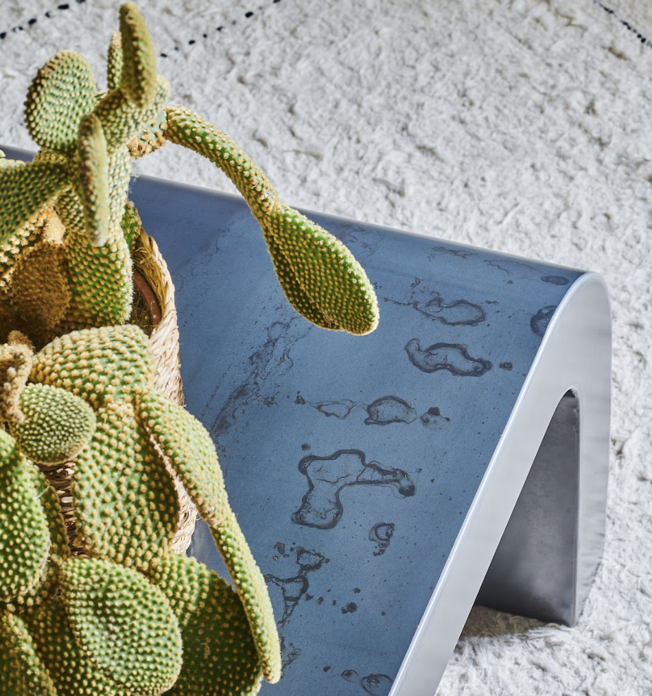 Table basse Gaïa en acier, design contemporain, mise en scène avec un cactus sur un tapis texturé.