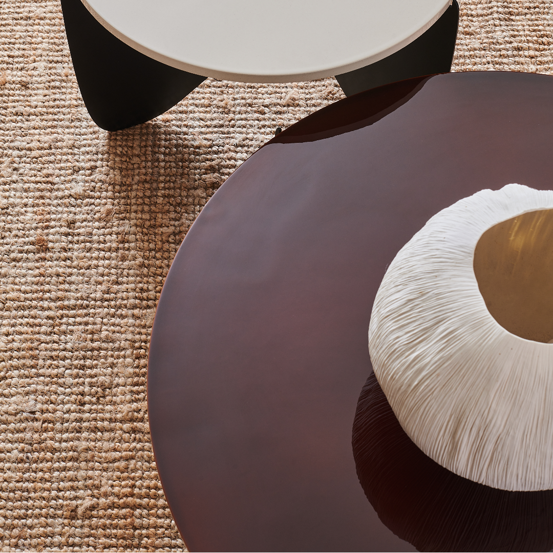 Table basse Aphrodite Duo en acier, design contemporain, sur tapis naturel, avec vase décoratif. Artisanat français de qualité.