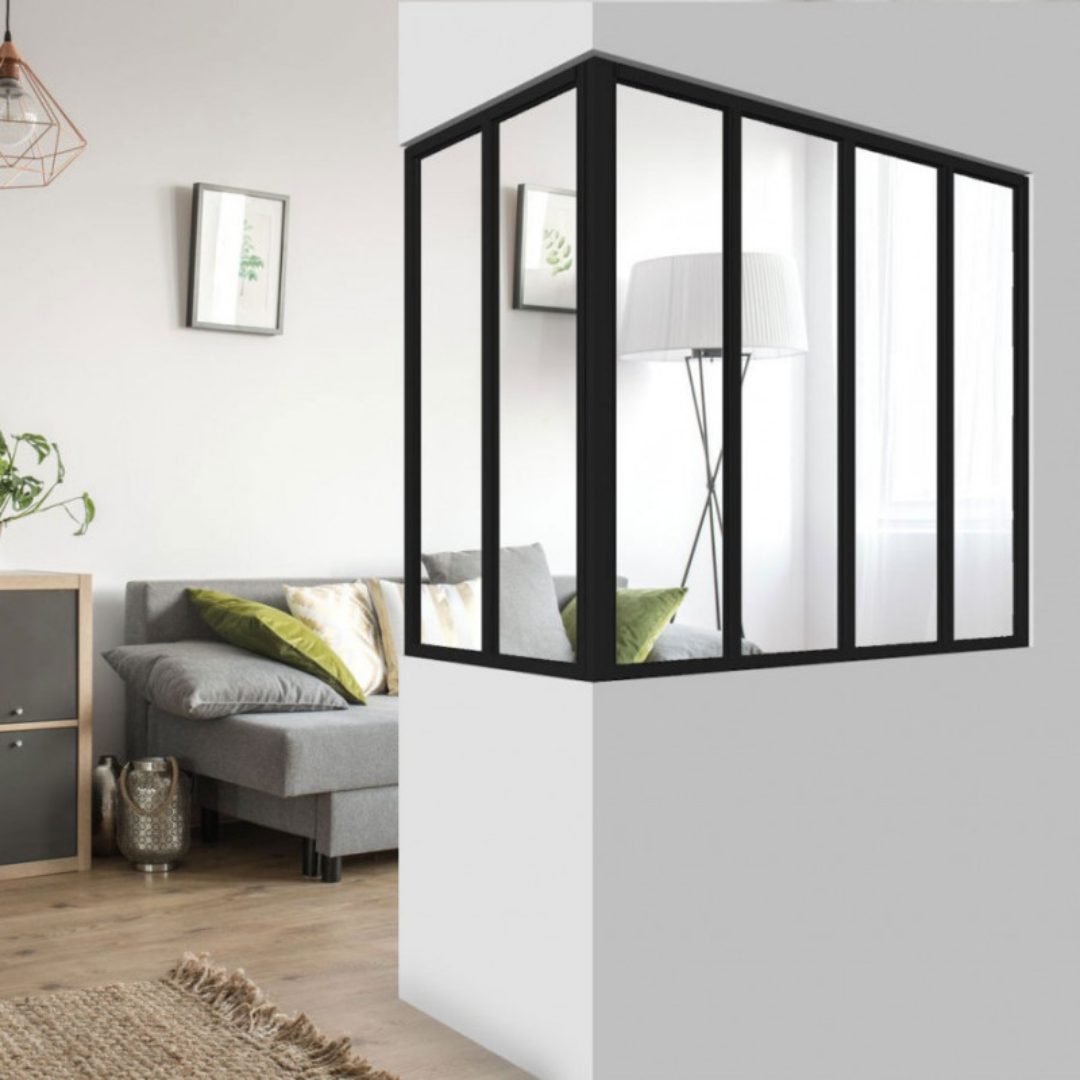 Verrière d'angle en acier noir dans un salon moderne, offrant une séparation lumineuse entre deux espaces.